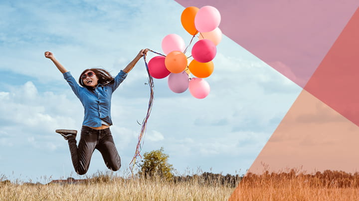 Mujer saltando feliz con globos