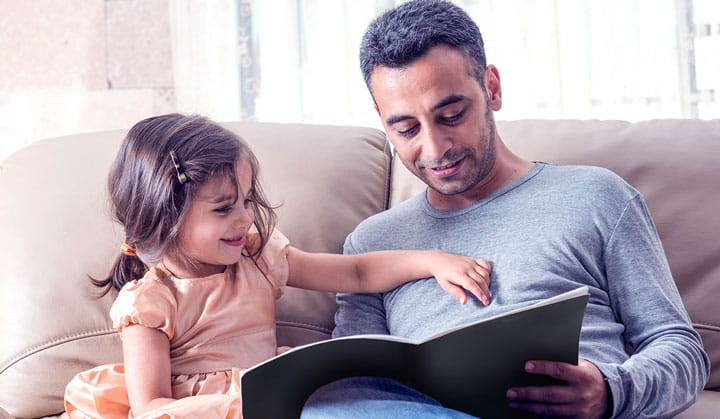 Padre leyendo una historia a su hija y disfrutando de más libertad con una línea de crédito de BOK.