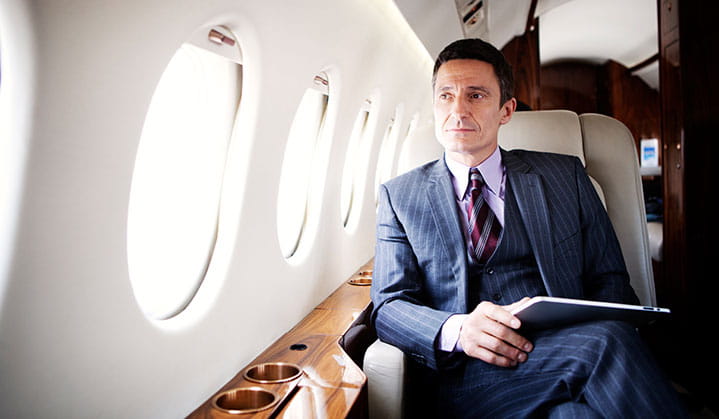 Propietario de negocio en un jet privado buscando opciones de financiamiento de aeronaves a través de BOK.