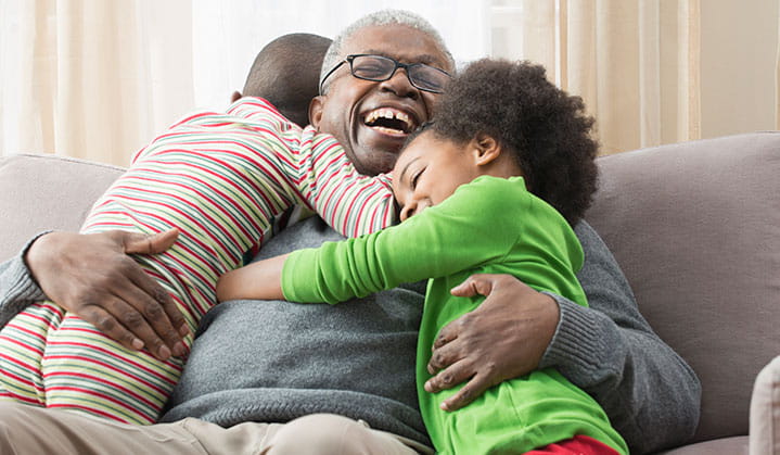 Abuelo abrazando a sus nietos que confía en su planificación de patrimonio y retiro a través de BOK.