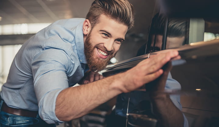 Man admiring his new car purchased with an Auto Loan