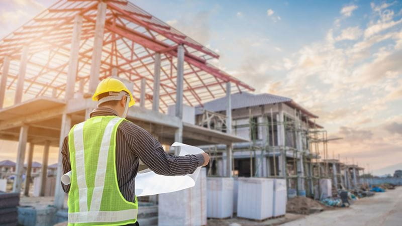 Capataz de construcción revisa planes para nuevo edificio ya que la Reserva Federal anunció que no aumentaría las tasas de interés en noviembre de 2023.